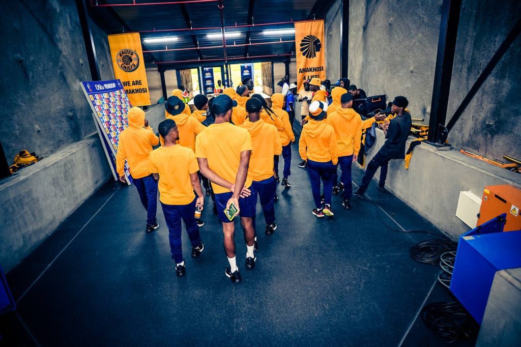 Several Kaizer Chiefs team walking to the field.