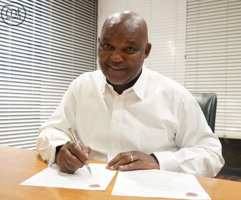 Pitso Mosimane signing paperwork.